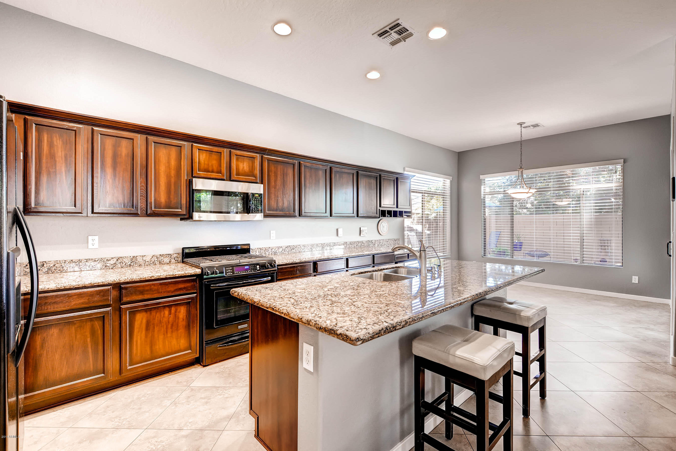 3829 East Carson Road Phoenix, AZ 85042 - Photo 8 of 28 a kitchen with granite countertop wooden cabinets and a granite counter tops