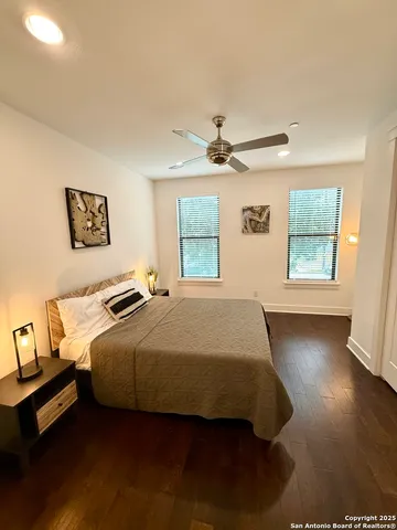 a bedroom with a bed a window and painting on the wall