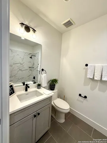 a bathroom with a sink mirror and toilet