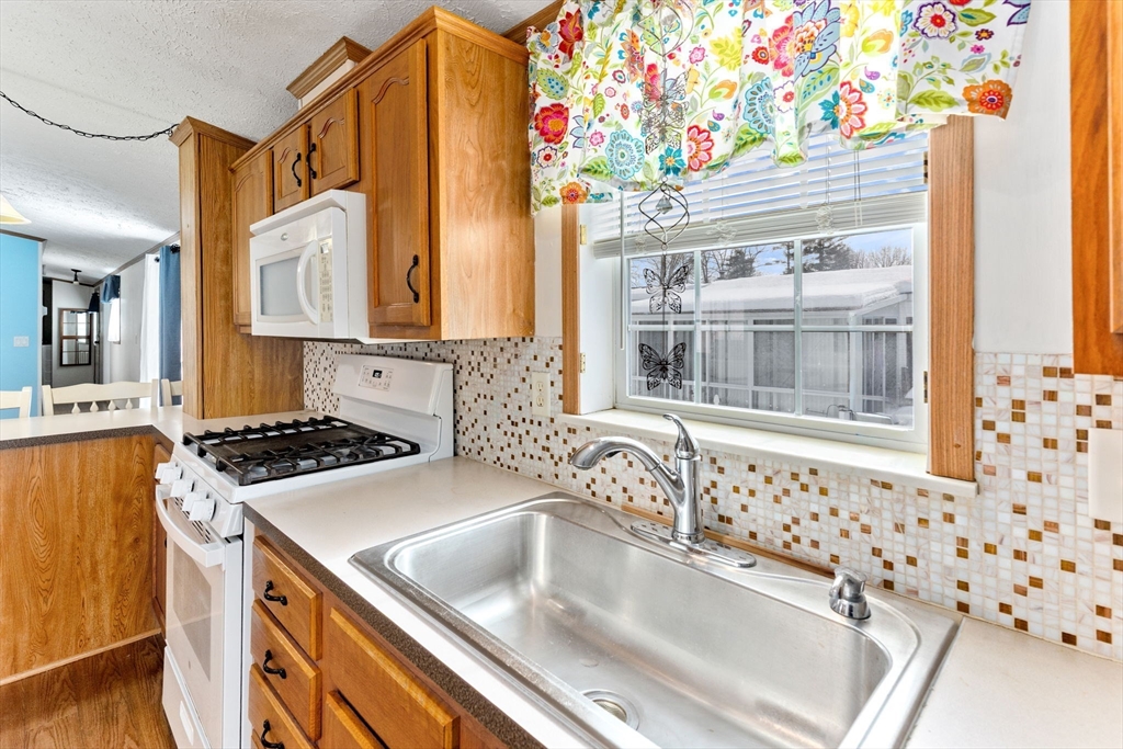 51 Tucker Terrace Raynham, MA 02767 - Photo 17 of 35 a kitchen that has a sink and a stove