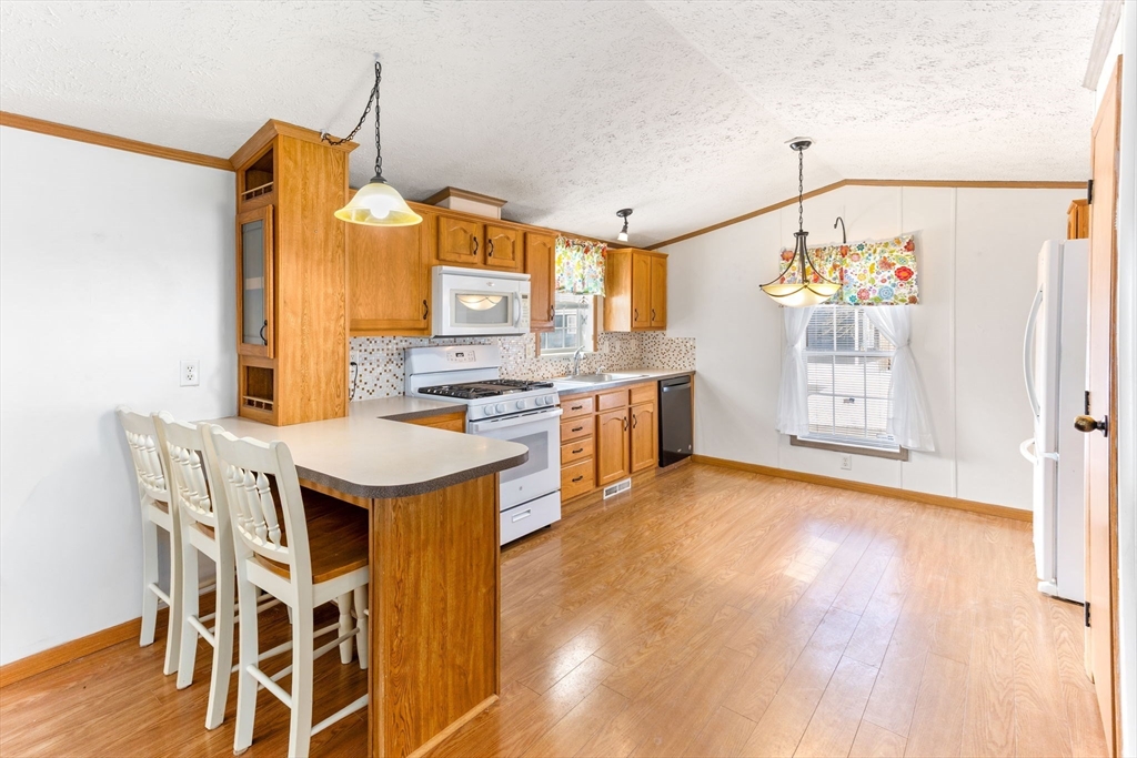 51 Tucker Terrace Raynham, MA 02767 - Photo 18 of 35 a kitchen with stainless steel appliances a stove a sink dishwasher and a refrigerator