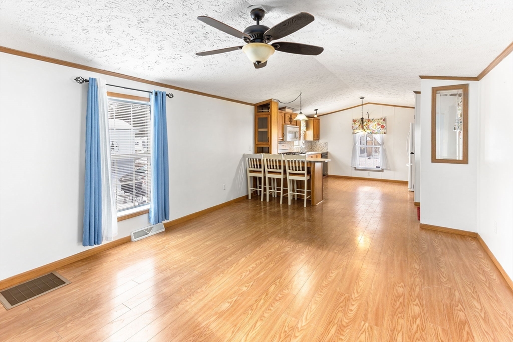 51 Tucker Terrace Raynham, MA 02767 - Photo 22 of 35 a view of a livingroom with furniture wooden floor a ceiling fan and windows