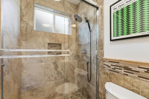 a bathroom with a toilet and a shower