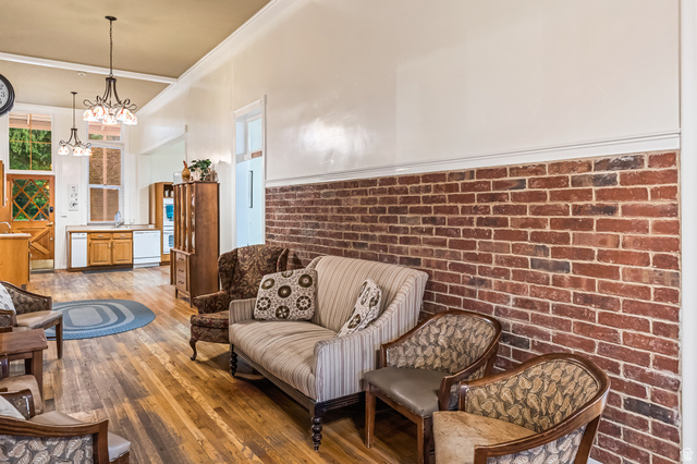 21 North Main Street Kingston, UT 84743 - Photo 59 of 107 Living area with brick wall, hardwood / wood-style flooring, and hanging lights