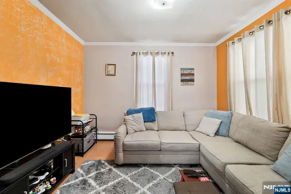 a living room with furniture a flat screen tv and a window