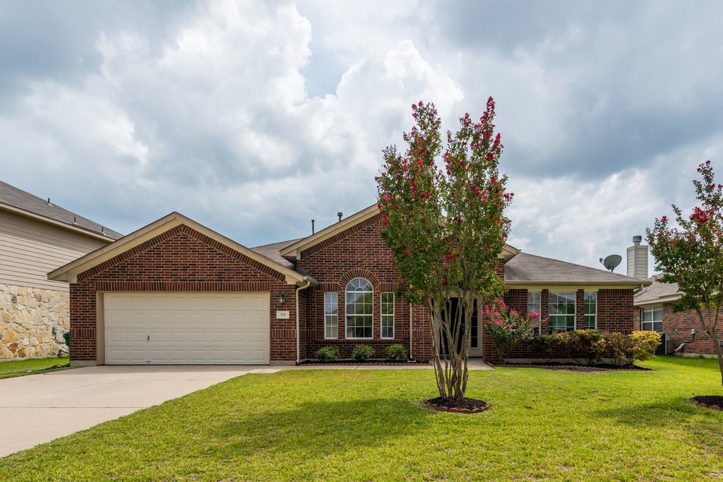 a front view of a house with a garden and trees