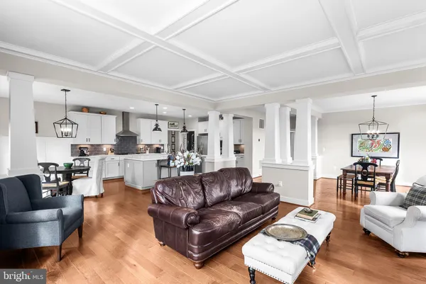 a large kitchen with cabinets chairs and wooden floor
