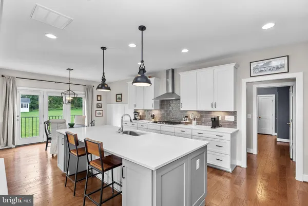 a kitchen with stainless steel appliances a sink a stove top oven a counter space and cabinets