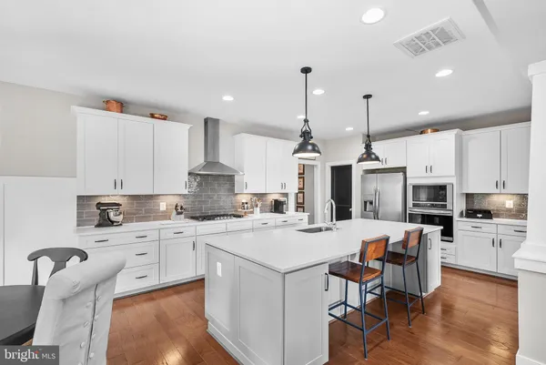 a dining room with furniture a chandelier and wooden floor