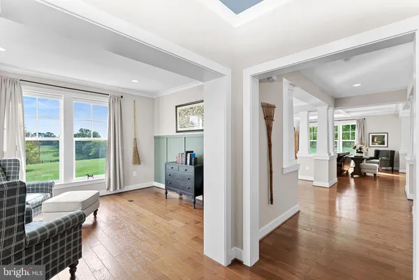 a living room with furniture large window and wooden floor