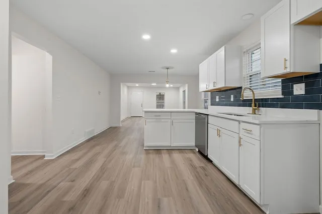 a kitchen with white cabinets stainless steel appliances