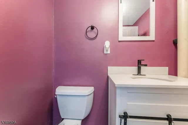 a bathroom with a toilet a sink and mirror