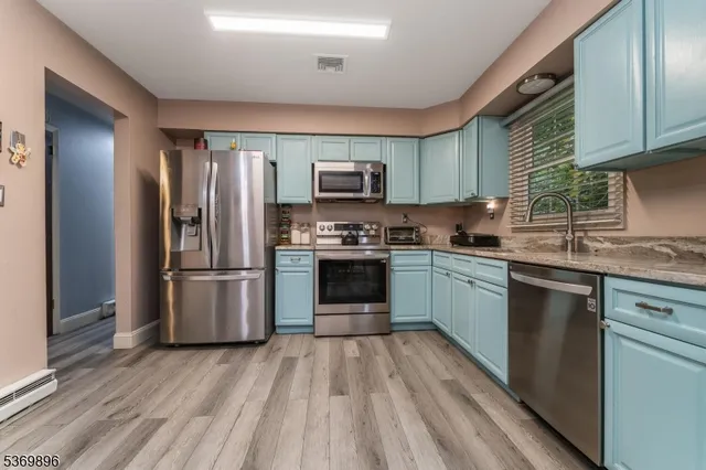 a kitchen with a refrigerator a stove top oven a sink and dishwasher