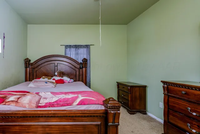 a bedroom with a bed and a dresser