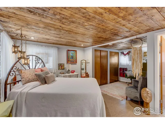 a bedroom with a bed a mirror on dresser and a table