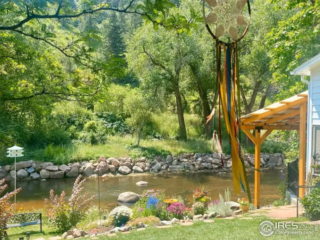 a front view of a building with a garden and trees
