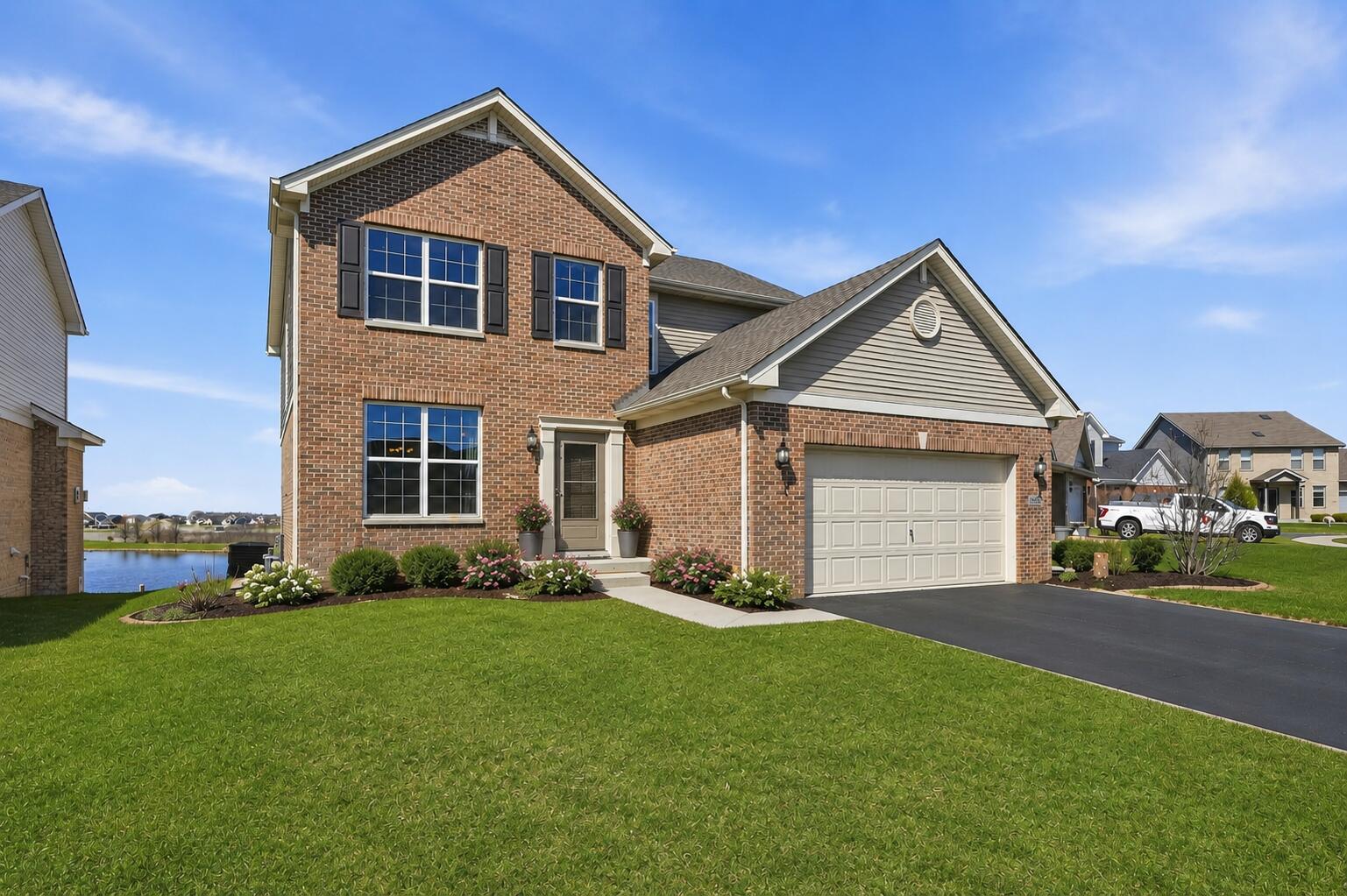 10322 Adler Cove St. John, IN 46373 - Photo 1 of 26 a front view of a house with a yard and garage