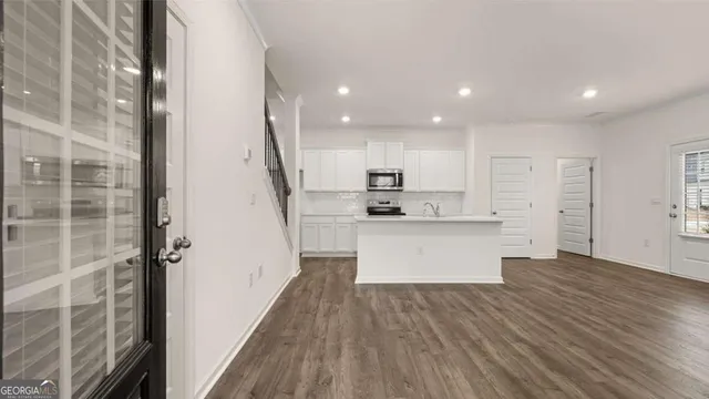 a view of kitchen with wooden floor and electronic appliances