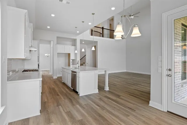 a large kitchen with a lot of counter space and wooden floor