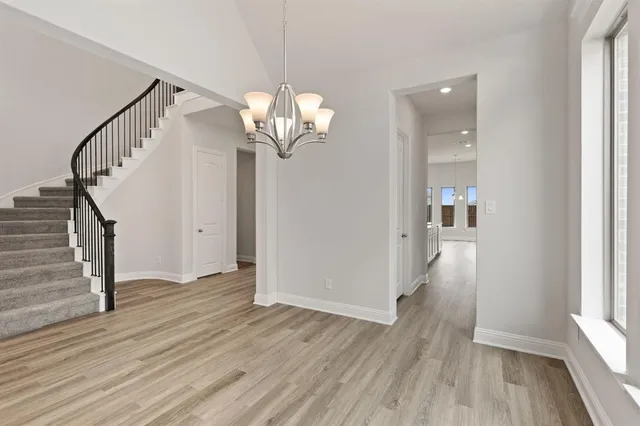 a view of a hallway with wooden floor and staircase