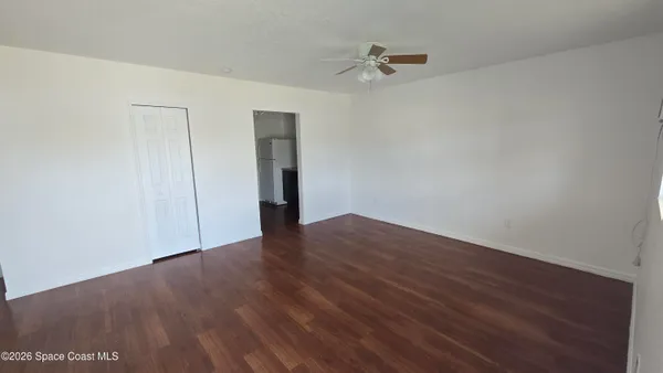 a view of an empty room with wooden floor