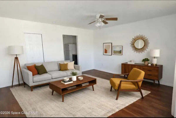 a living room with furniture and wooden floor