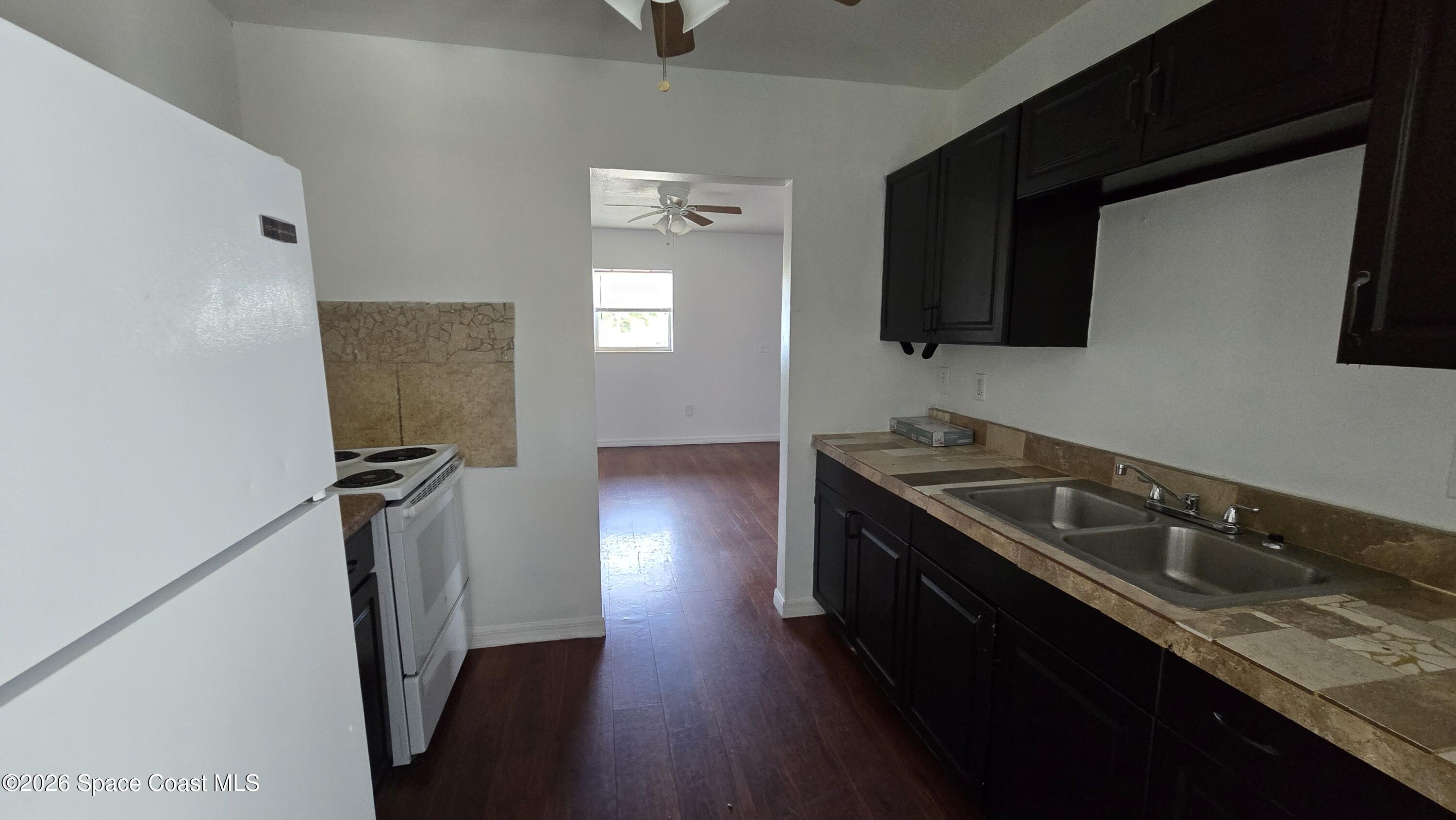 1026 Bacon Circle Northeast, Unit A Palm Bay, FL 32905 - Photo 6 of 12 a kitchen with a sink appliances and cabinets