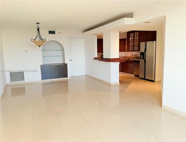 a view of a livingroom with furniture and a refrigerator