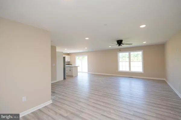 a view of a big room with wooden floor and windows