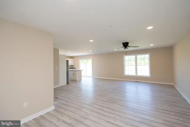 a view of a big room with wooden floor and windows