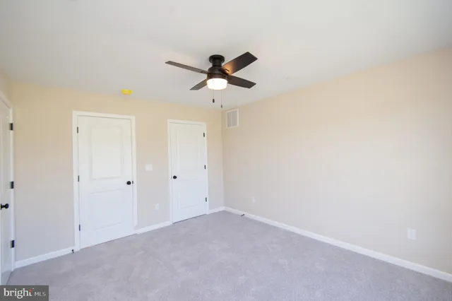 a view of a room with a ceiling fan and window