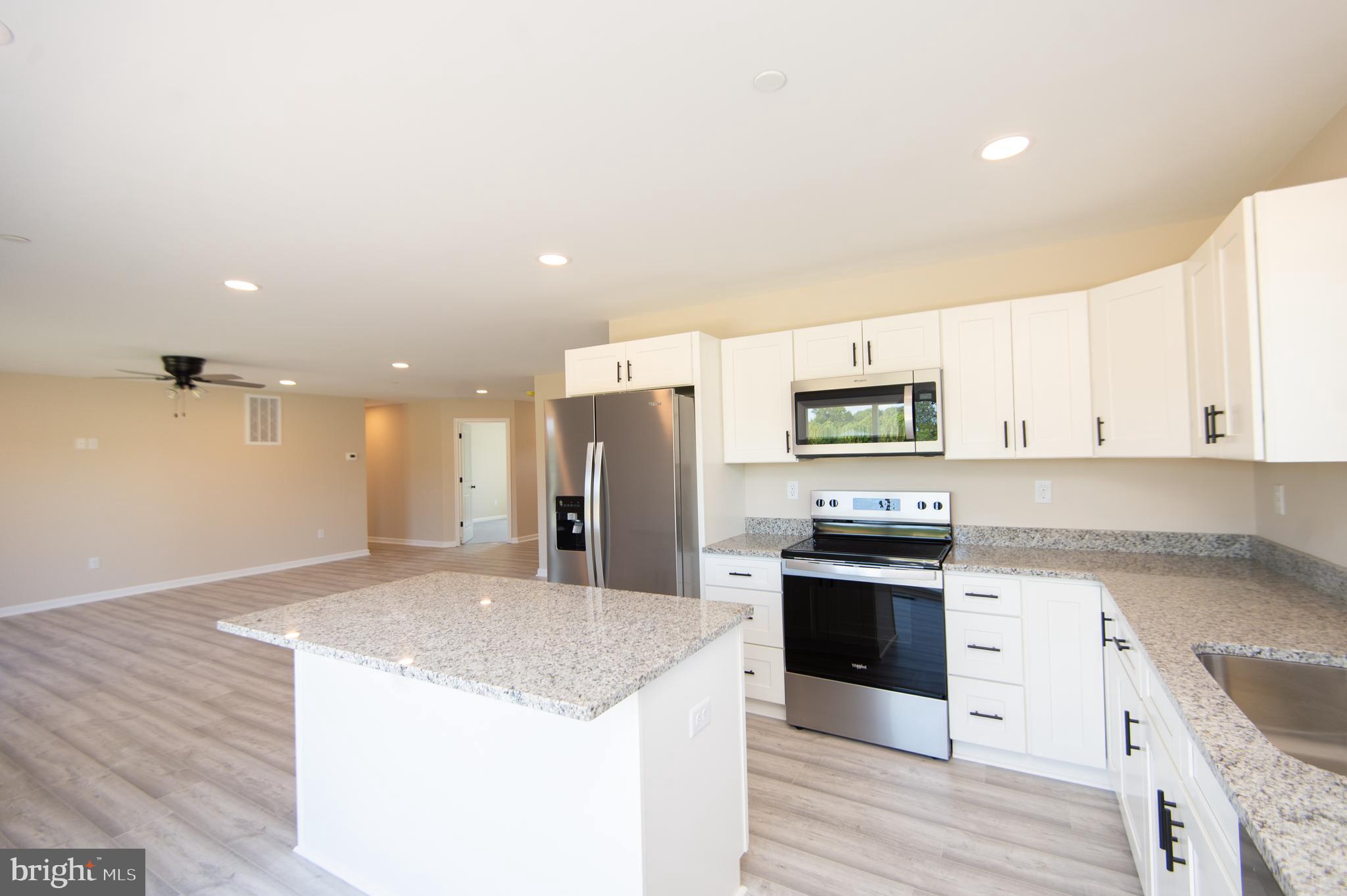 Wrights Rest Road Hurlock, MD 21643 - Photo 10 of 25 a kitchen with stainless steel appliances kitchen island granite countertop a refrigerator and a stove top oven