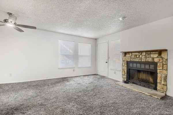 an empty room with a fireplace and window