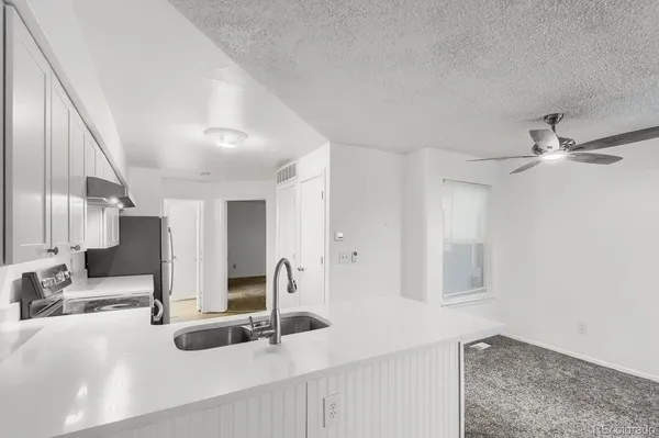 a view of a kitchen with kitchen island a sink appliances and a counter top space