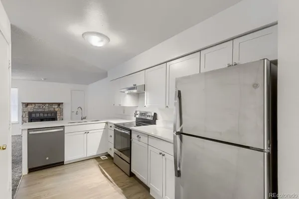 a kitchen with white cabinets and white appliances