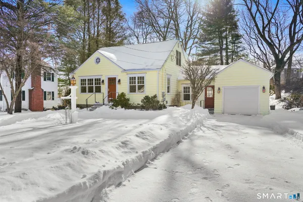 a view of a white house with a yard covered in snow