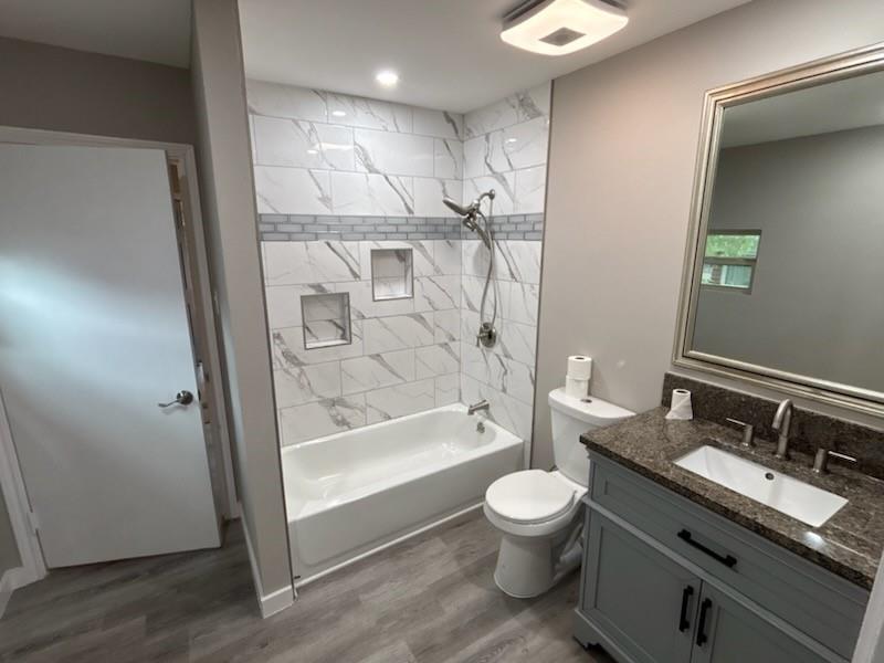 1570 Sutter Street Dallas, TX 75216 - Photo 13 of 17 a bathroom with a granite countertop toilet a sink and a mirror
