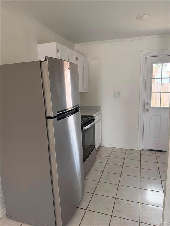 2612 West Mile 17 1/2 Road, Unit 12 Edinburg, TX 78541 - Photo 3 of 10 Kitchen featuring stainless steel appliances, white cabinetry, light-toned countertops, and square tile flooring