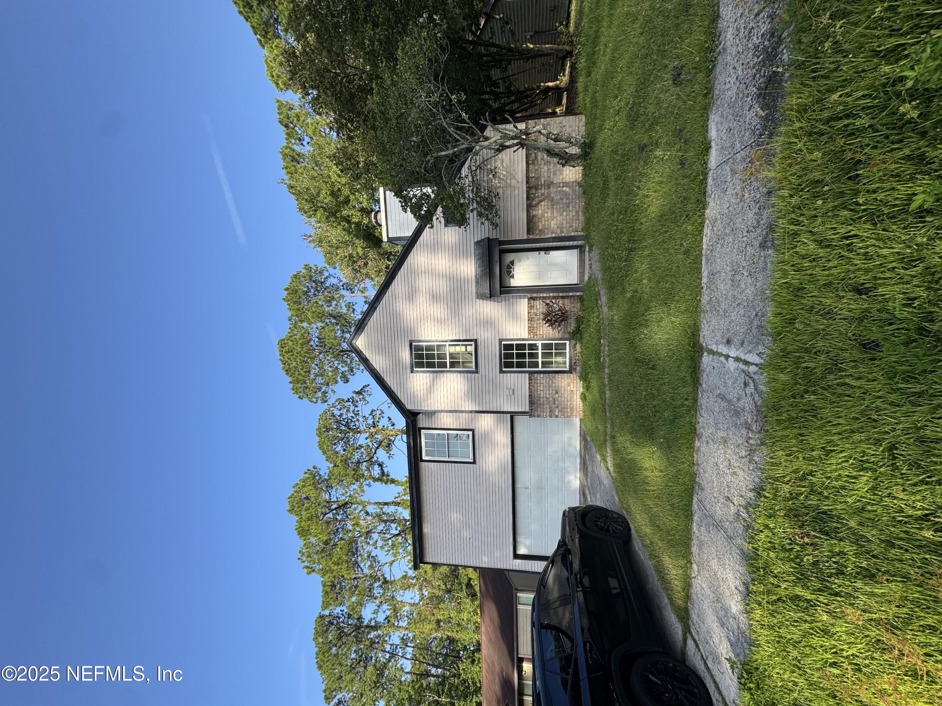 a front view of a house with a garden and yard