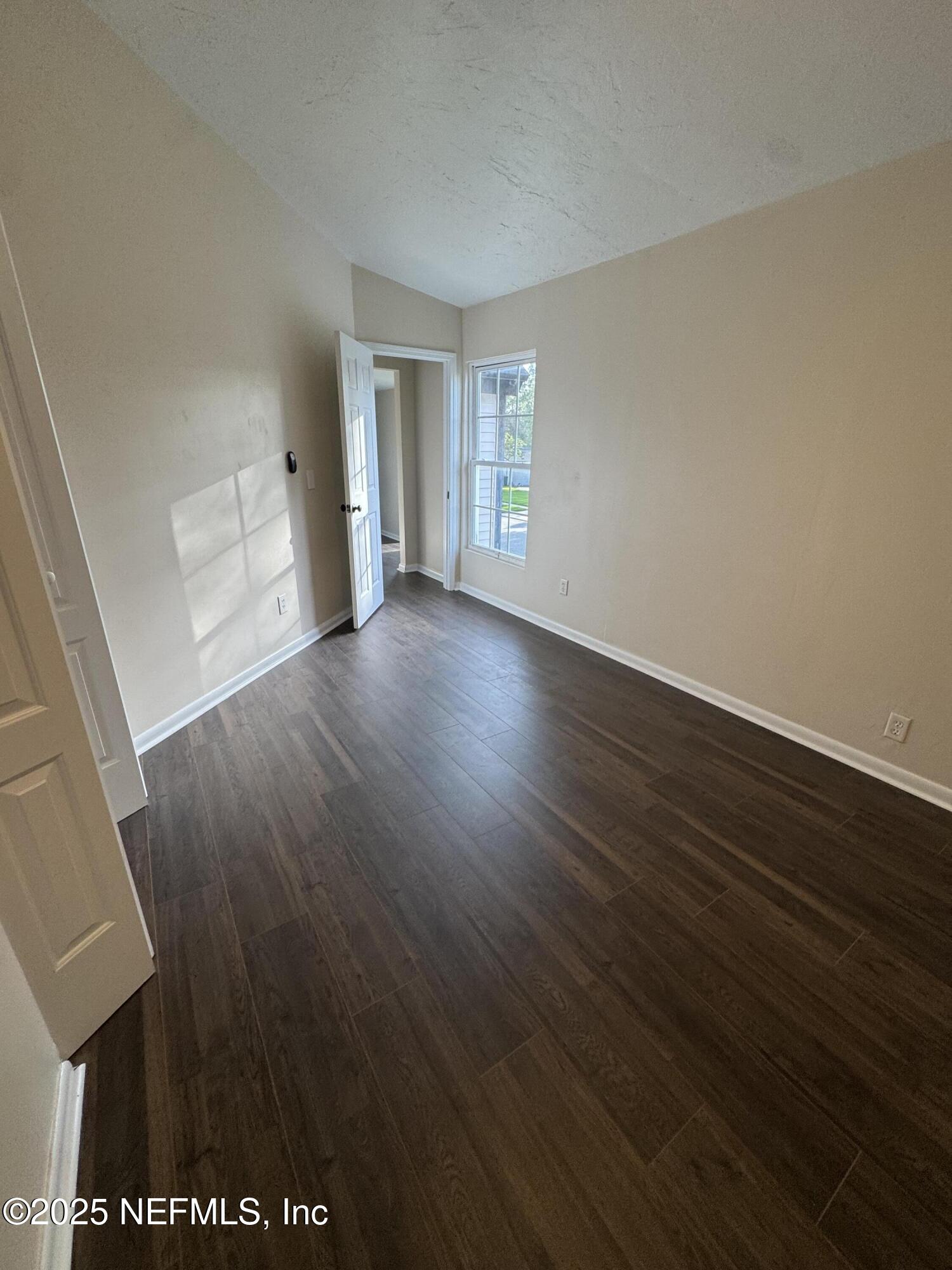 10244 Pine Breeze Road South Jacksonville, FL 32257 - Photo 13 of 16 an empty room with wooden floor and windows