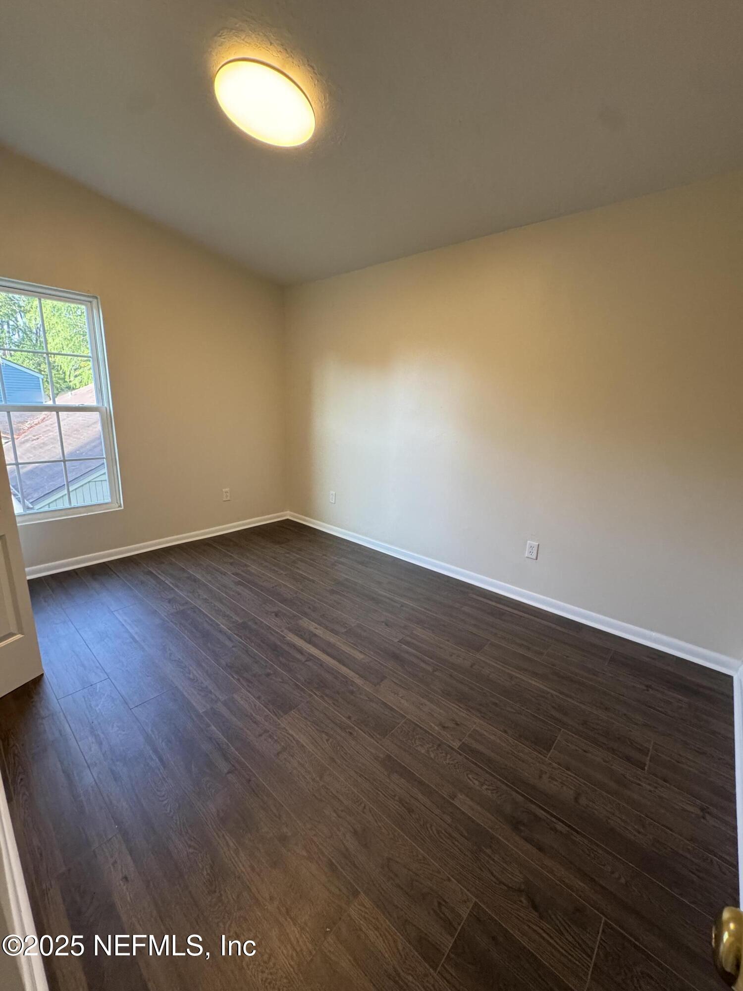 10244 Pine Breeze Road South Jacksonville, FL 32257 - Photo 14 of 16 an empty room with wooden floor and windows