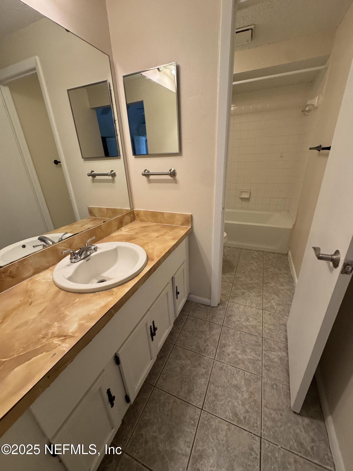 10244 Pine Breeze Road South Jacksonville, FL 32257 - Photo 10 of 16 a bathroom with a granite countertop sink a mirror and a shower