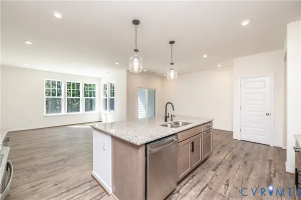 a kitchen with a sink and wooden floor