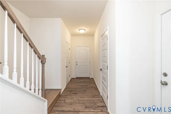 a view of a hallway with wooden floor and staircase