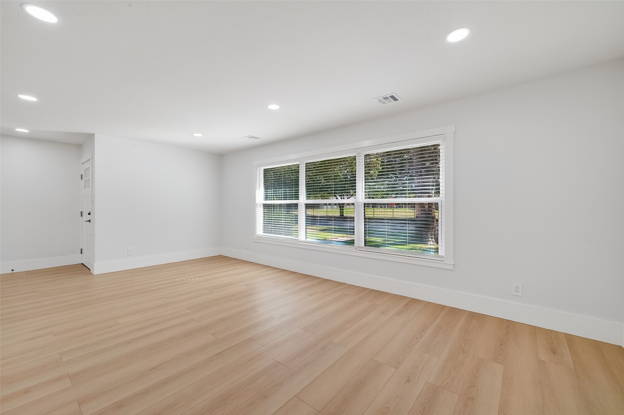 9770 Cedardale Drive Houston, TX 77055 - Photo 11 of 40 an empty room with wooden floor and windows