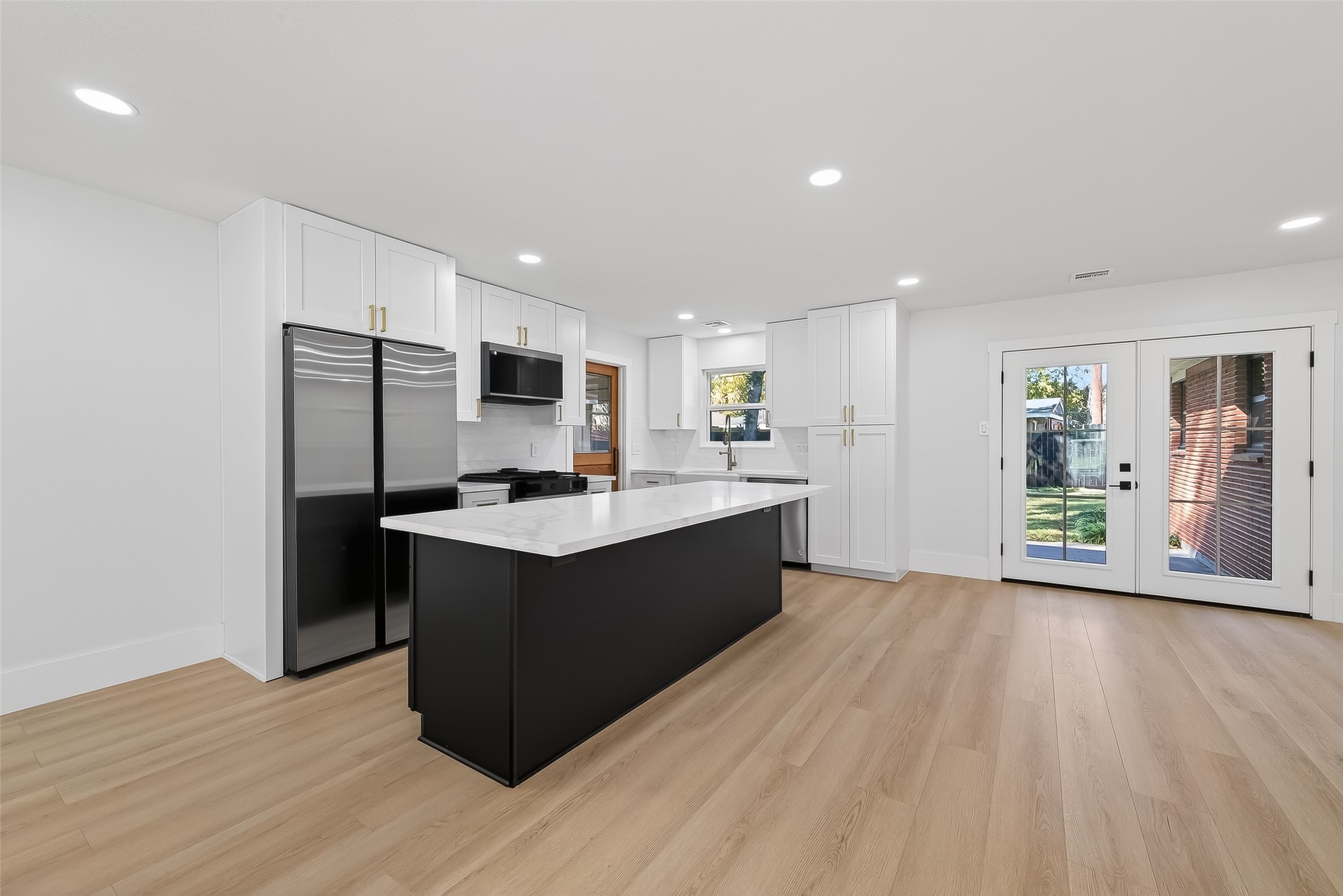 9770 Cedardale Drive Houston, TX 77055 - Photo 13 of 40 a large kitchen with stainless steel appliances granite countertop a large counter top and wooden floors