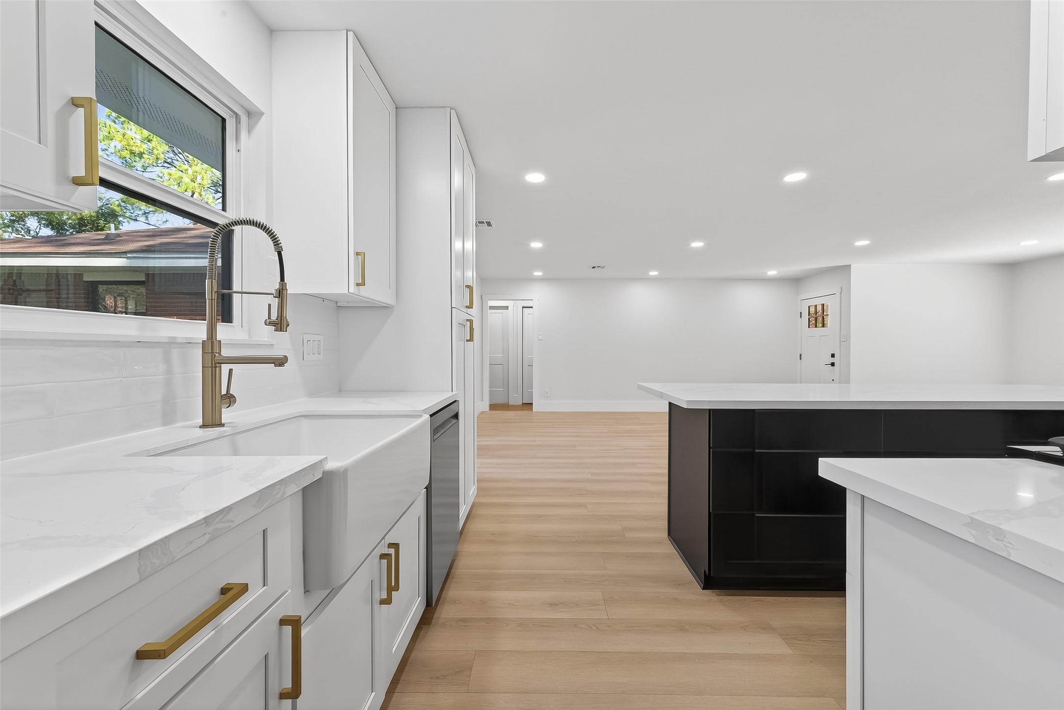 9770 Cedardale Drive Houston, TX 77055 - Photo 17 of 40 a large white kitchen with a sink and dishwasher a stove with wooden floor
