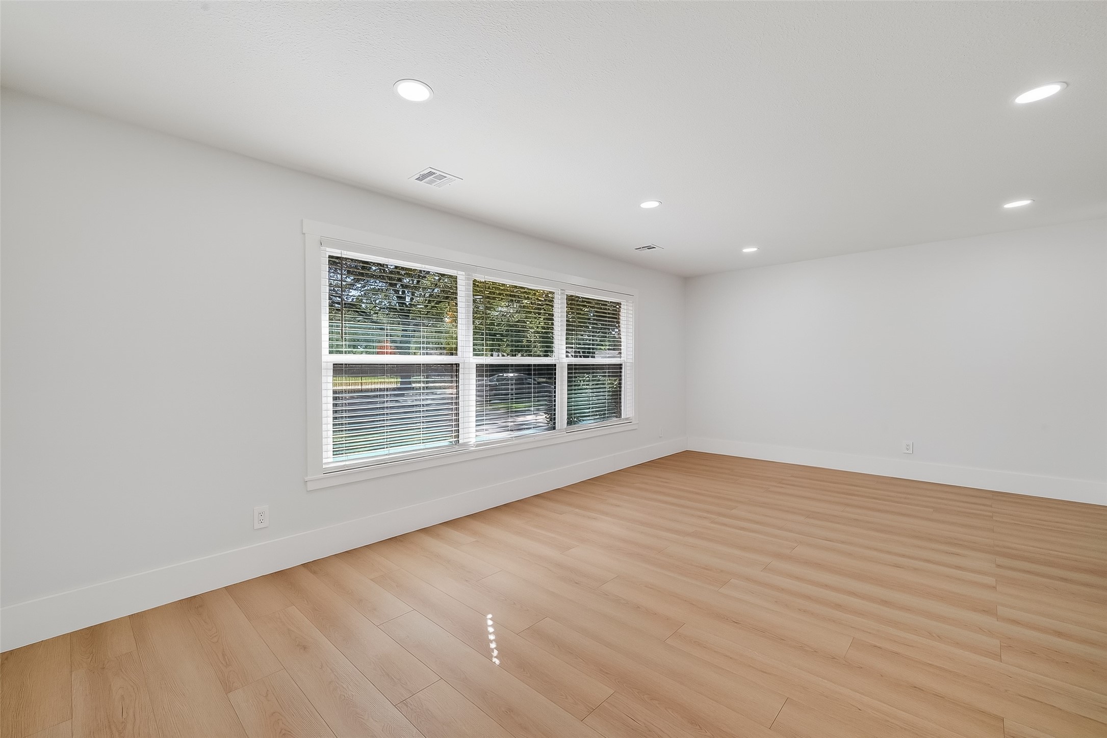 9770 Cedardale Drive Houston, TX 77055 - Photo 8 of 40 an empty room with wooden floor and windows