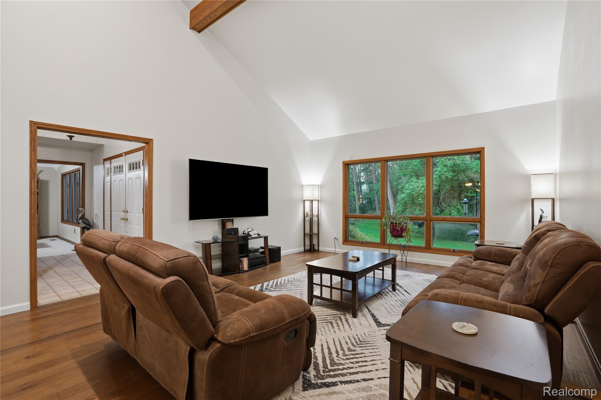 68345 Romeo Plank Road Ray, MI 48096 - Photo 29 of 52 Vaulted ceiling living area featuring wood-finish flooring and a large window overlooking a verdant exterior