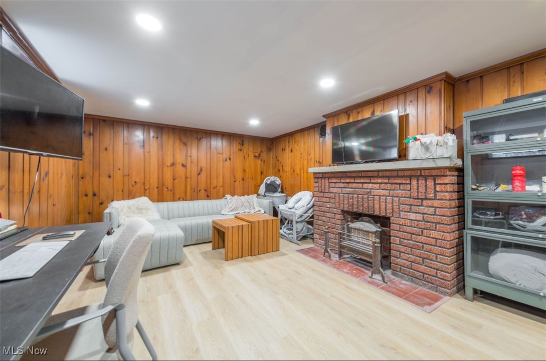 15500 Greenway Road Cleveland, OH 44111 - Photo 33 of 36 Living area featuring wood walls, light wood-style floors, recessed lighting, a fireplace, and crown molding
